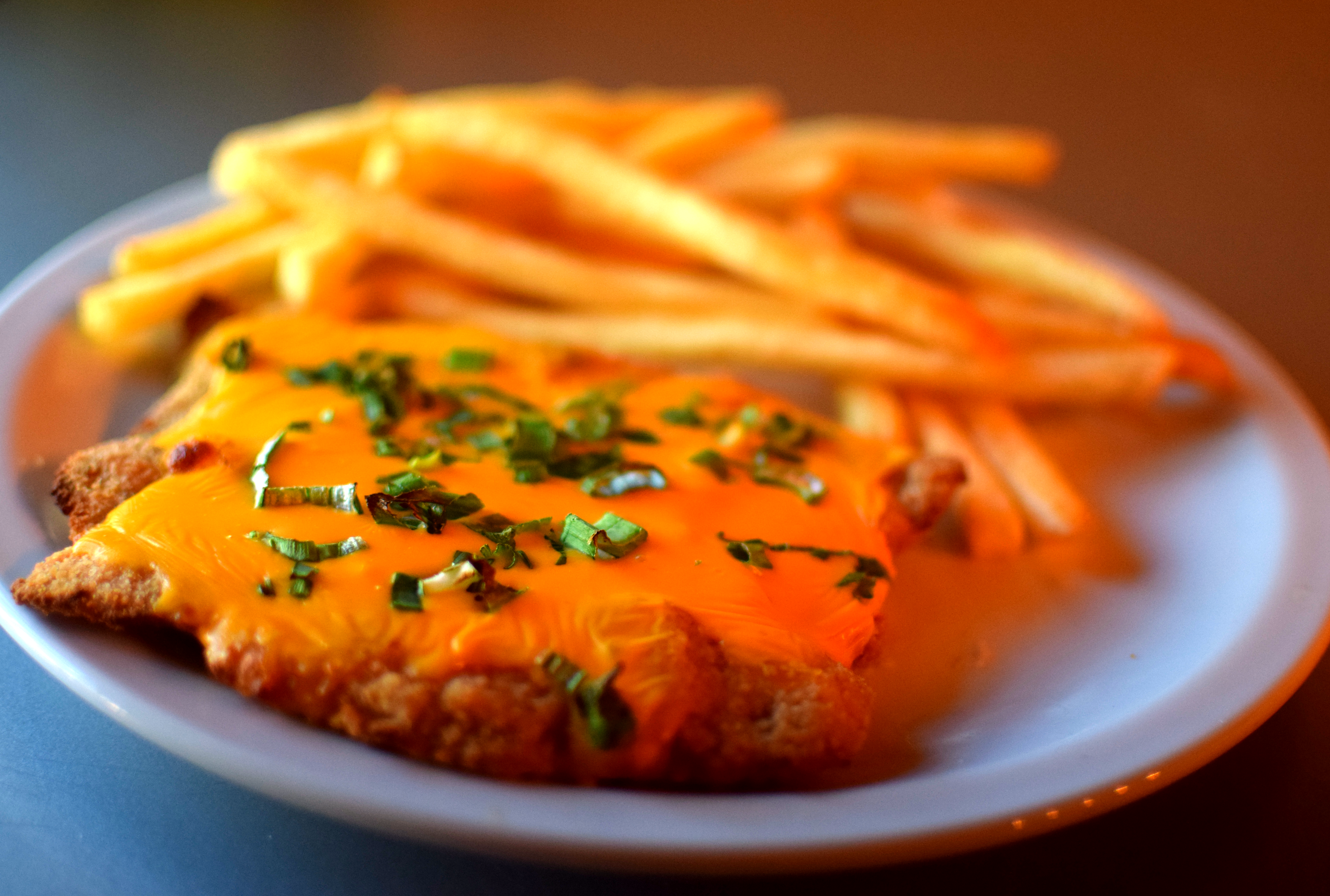 Milanesa de carne con cheddar y verdeo con papas